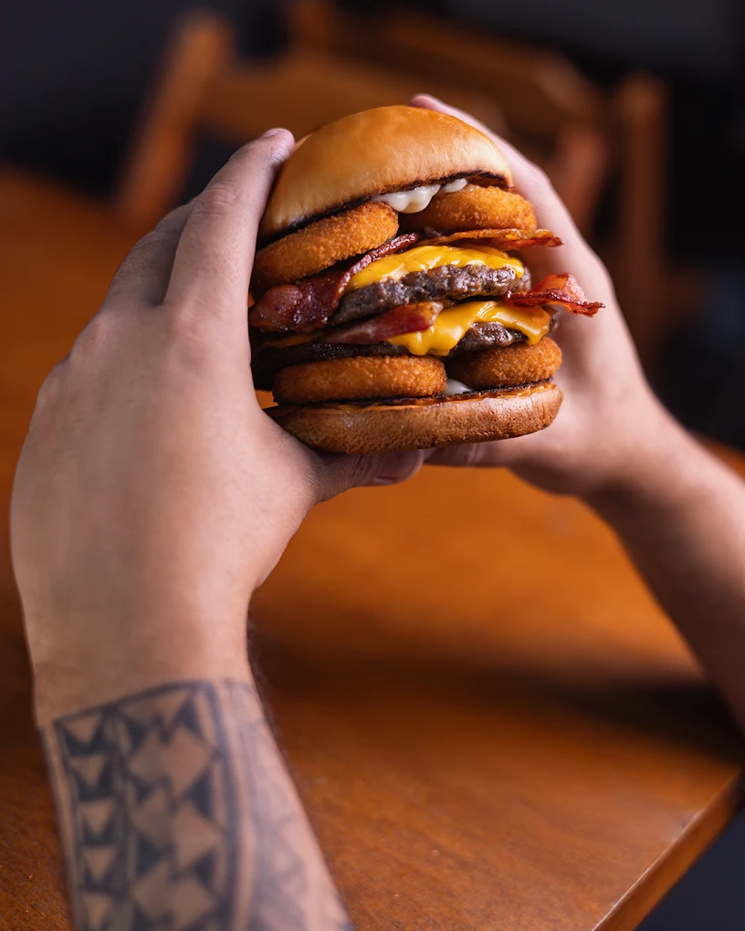 Cliente segurando um burger da Chicago